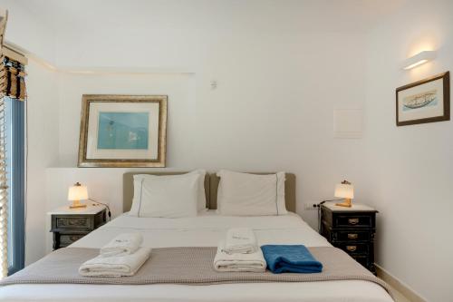 a bedroom with a bed with two towels on it at Blueros - Olive suite in Megas Yialos-Nites