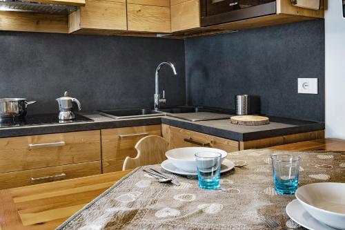 eine Küche mit einem Tisch, auf dem Teller und Gläser stehen in der Unterkunft Chalet Diamond - AffittiPontediLegno in Ponte di Legno
