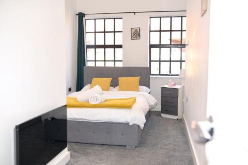 a bedroom with a bed with yellow pillows at Modern home in Birmingham in Birmingham
