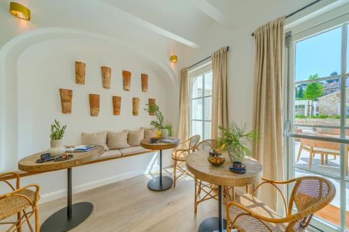 a living room with a couch and tables and chairs at Hotel Brattia, Adults Only, Heated Pool, A la Carte Breakfast, Postira, Brač Island in Postira