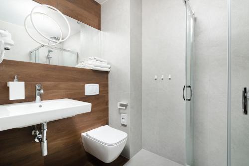 a bathroom with a toilet and a sink and a shower at Hotel Wisła Premium in Wisła