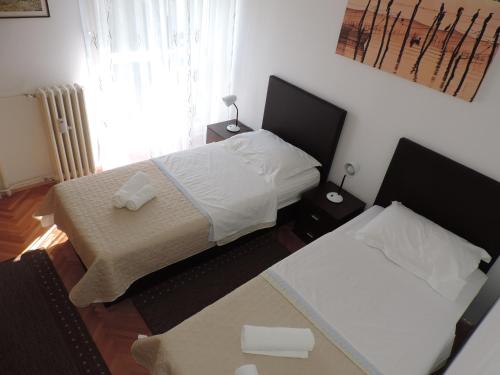 niewielka sypialnia z 2 łóżkami i oknem w obiekcie Apartment Ivana w Splicie