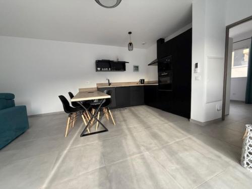 a living room with a table and a kitchen at E casette in Oletta