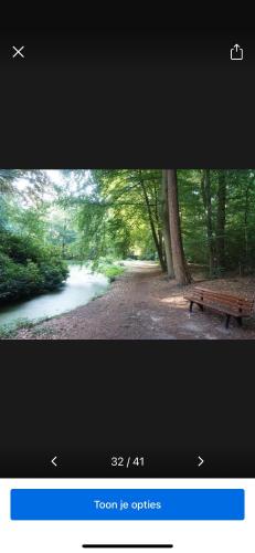 a picture of a park with a bench next to a river at Appartement de Tuinkamer in Ter Apel