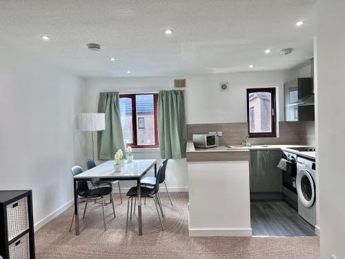 インバネスにあるElegant Apartment In City Centreのテーブルと椅子のあるキッチンとダイニングルーム