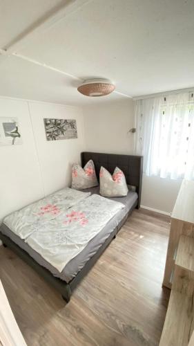 a bedroom with a bed with pillows on it at Bungalowdorf Briesensee in Neu Zauche