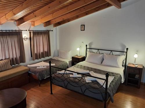 een slaapkamer met 2 bedden en een bank bij Koxylia apts in Mochlos