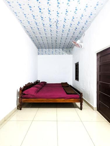 a bedroom with a bed in a room with a ceiling at Wintervilla Cottages in Meppādi