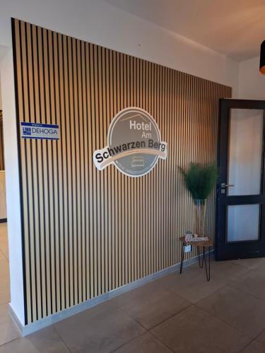a hotel sign on a striped wall in a lobby at Hotel Am Schwarzen Berg in Stade
