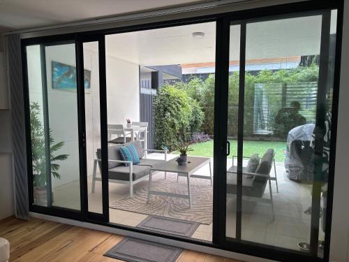 a living room with a sliding glass door at Sandy Paws and Salty Zoomies in Huskisson