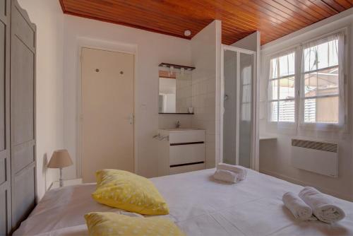 une chambre avec un lit avec deux serviettes dessus dans l'établissement Maisonnette de l'Aiguillon, à Arcachon