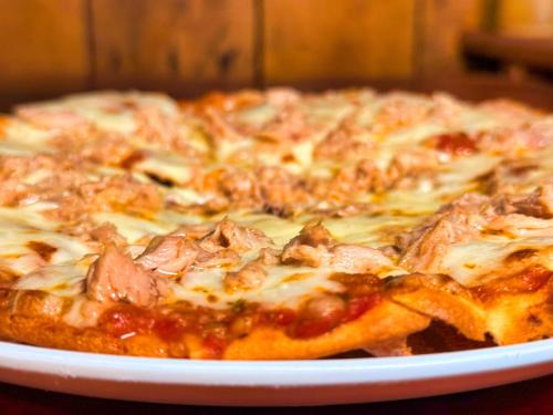 a pizza sitting on a plate on a table at Kohrong Central Beach in Koh Rong Island