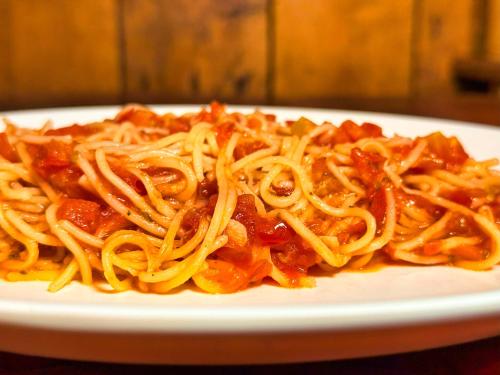 a plate of spaghetti with sauce on a table at Kohrong Central Beach in Koh Rong Island