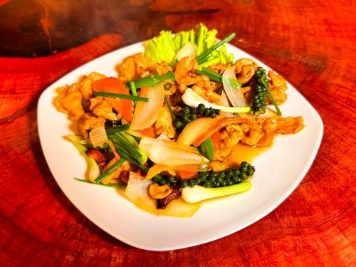 a plate of food with vegetables on a table at Kohrong Central Beach in Koh Rong Island