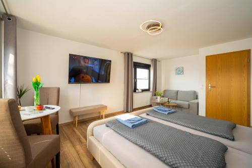 a bedroom with a bed and a living room at Ferienwohnung Haus am Seeufer Steuerbord in Waren
