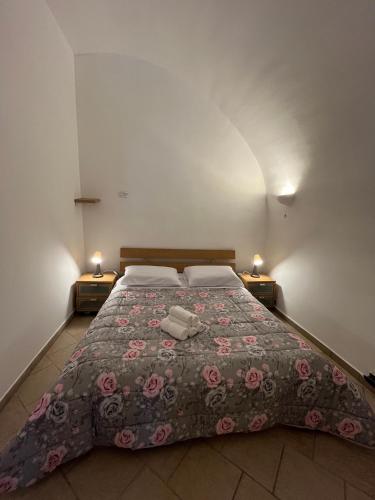 a large bed in a room with two lamps at Family in Massafra