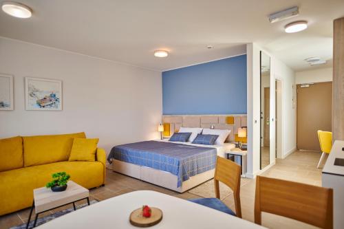 a bedroom with a bed and a living room at Arancini Residence in Vodice