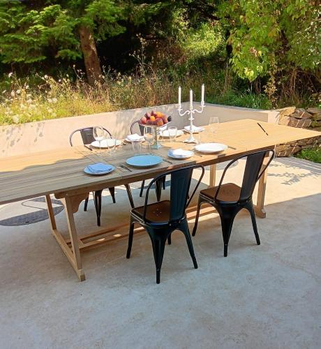 une table en bois avec deux chaises et une table avec des verres à vin dans l'établissement La Maison Nid, à Oradour-sur-Vayres