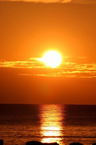 a sunset over the ocean with the sun in the sky at Simo'sunset House in Focene