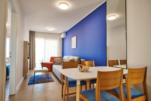 a living room with a table and a blue wall at Arancini Residence in Vodice