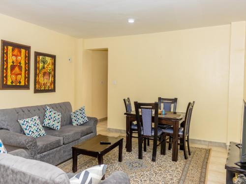 a living room with a couch and a table and chairs at Nimmoh's Homestays at Kishan Towers in Nanyuki
