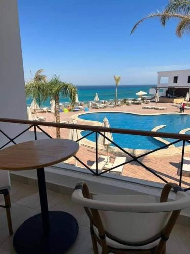 a balcony with a table and a view of a swimming pool at Miral Resort in Ain Sokhna