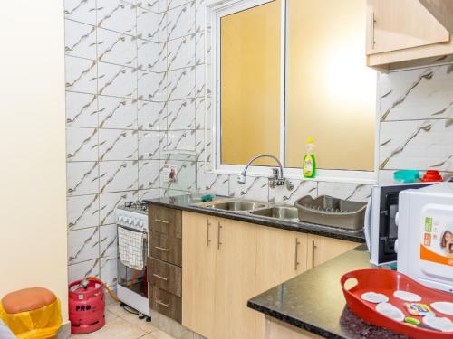 a kitchen with a sink and a microwave at Nimmoh's Homestays at Kishan Towers in Nanyuki