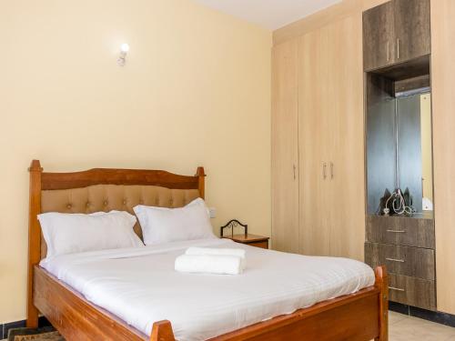 a bedroom with a large bed with white sheets at Nimmoh's Homestays at Kishan Towers in Nanyuki