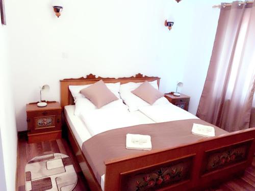 a bedroom with a large bed with two night stands at Gasthaus Casa Kugler in Anina
