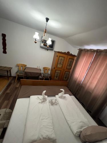 two swans sitting on a bed in a room at Gasthaus Casa Kugler in Anina