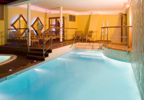 - une piscine dans un hôtel avec des chaises et des tables dans l'établissement L'Appartement de la Matelote face mer 5 personnes - 3ème étage sans ascenseur, à Boulogne-sur-Mer