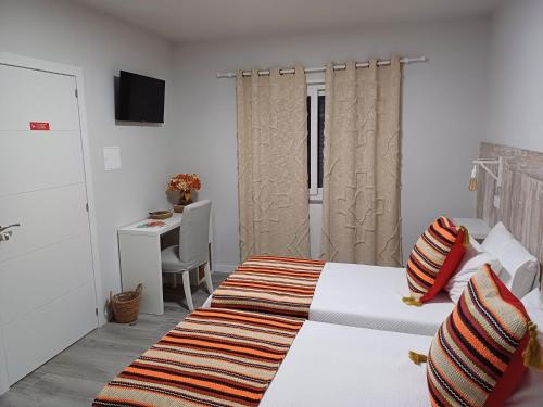 a bedroom with a bed and a desk and a table at Casa da Vila in Campo Maior