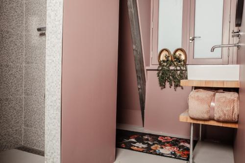 a bathroom with pink walls and a shower at Boutique Hotel Noordeinde in Rijnsburg
