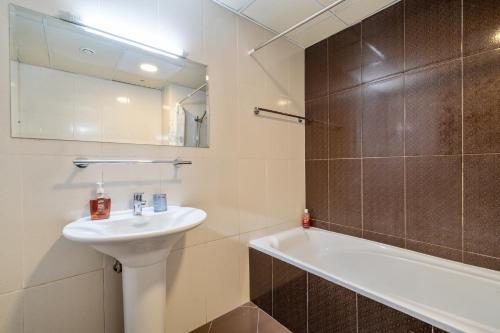 a bathroom with a sink and a bath tub at Live so close to beach - Al Marjan Island in Ras al Khaimah