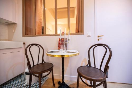 - une petite table et deux chaises dans la cuisine dans l'établissement Vivez le Paris d'Emily In Paris, à Paris