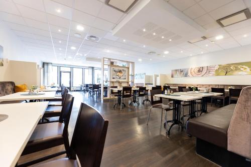 a dining room with tables and chairs in a restaurant at Good Morning+ Nyköping in Nyköping