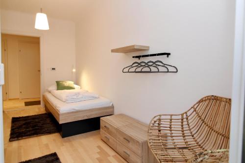 a small room with a bed and a chair at Graz central Penthouse Style Apt in Graz