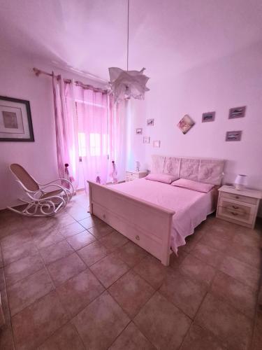 a bedroom with a large bed and a chair at Casa vacanze zona mare in Quartu SantʼElena