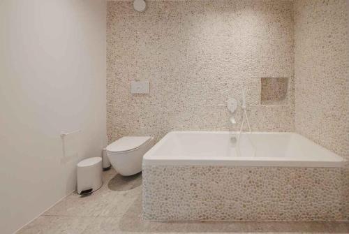 a bathroom with a tub and a toilet at Gialova SUNSET VILLA with Seaview & Private Pool in Gialova