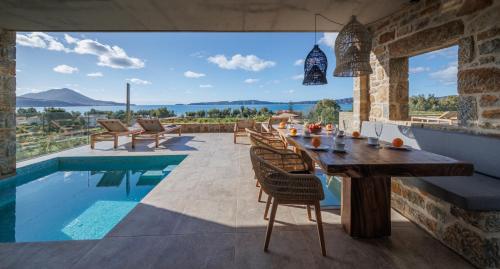 a dining room with a table and a swimming pool at Gialova SUNSET VILLA with Seaview & Private Pool in Gialova
