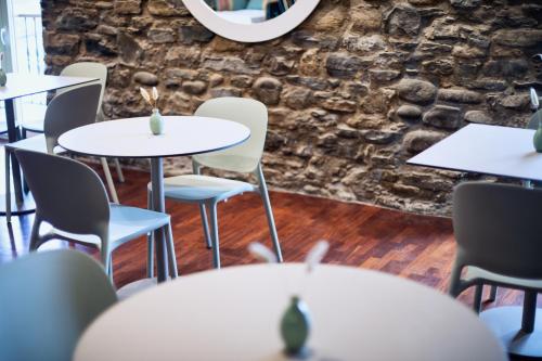 a room with tables and chairs and a stone wall at Katrapona in Getaria