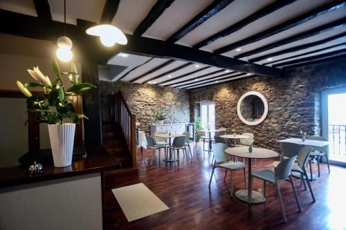 a restaurant with tables and chairs and a stone wall at Katrapona in Getaria