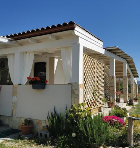 a white house with a fence and flowers at Casa Cocco in Sant' Isidoro
