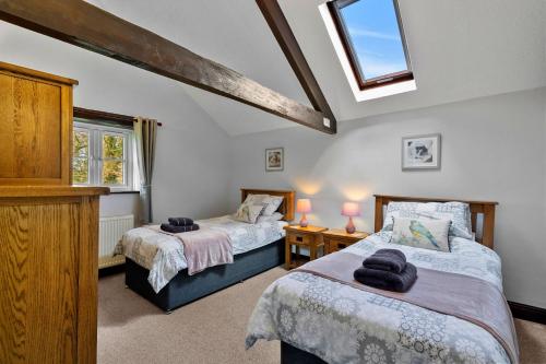 two beds in a room with two windows at Finest Retreats - Cowslip in Bradworthy