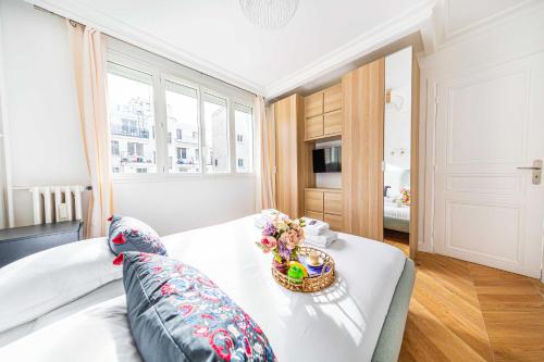 - une chambre dotée d'un lit avec un bol de fleurs dans l'établissement Superb Trocadero Eiffel Tower apartment, à Paris