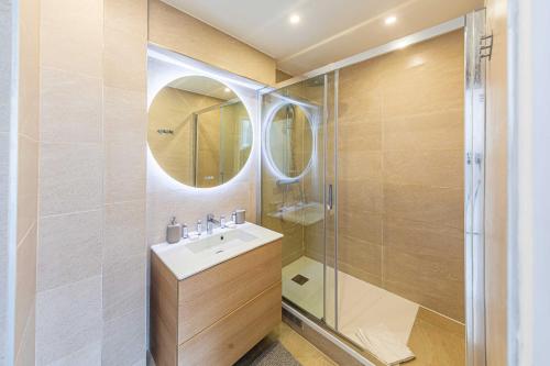 une salle de bain avec un lavabo et une douche dans l'établissement Superb Trocadero Eiffel Tower apartment, à Paris