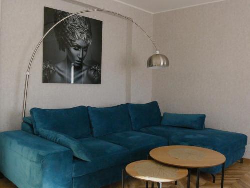 a living room with a blue couch and two tables at City Center Turu str apartments, parking, Tartu Home in Tartu
