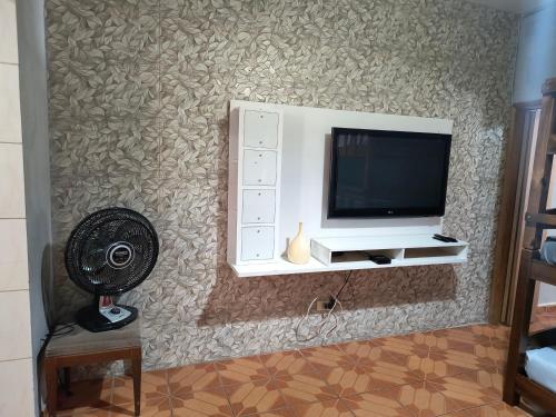 a room with a wall with a tv and a fan at Expo São Paulo, casa aconchegante in Sao Paulo