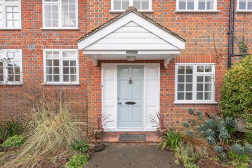 a red brick house with a white door at The Little House, Southwold in Southwold