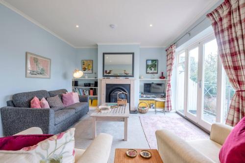 a living room with a couch and a fireplace at The Little House, Southwold in Southwold